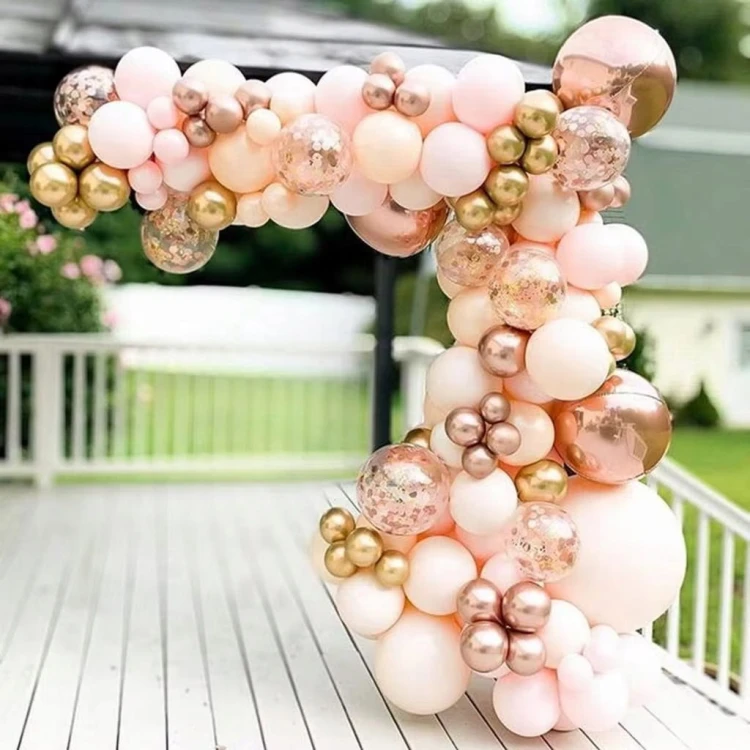 Girlanda z balonów Rose Gold i brzoskwiniowych w eleganckiej aranżacji przy stole na przyjęcie okolicznościowe.