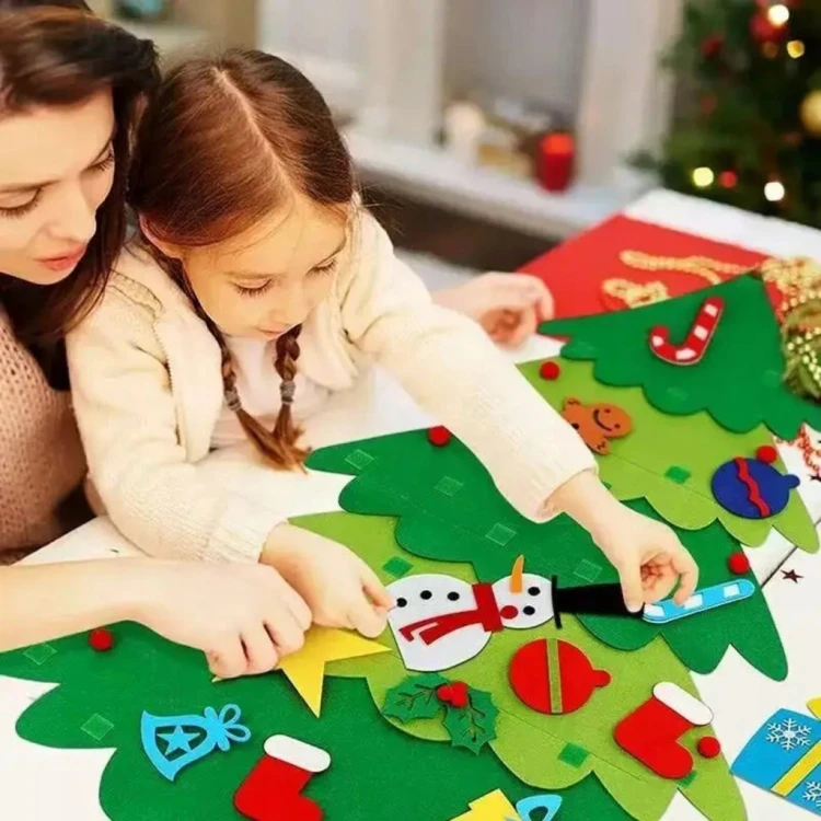 Dziecko dekorujące filcową choinkę ozdobami na rzepy